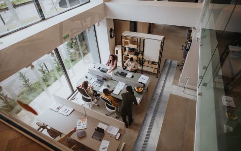 Top view of a bright modern office space with employees at desks working.